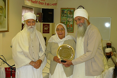s harcharan s randhawa and bibi baldev kaur receive award from s joginder singh.